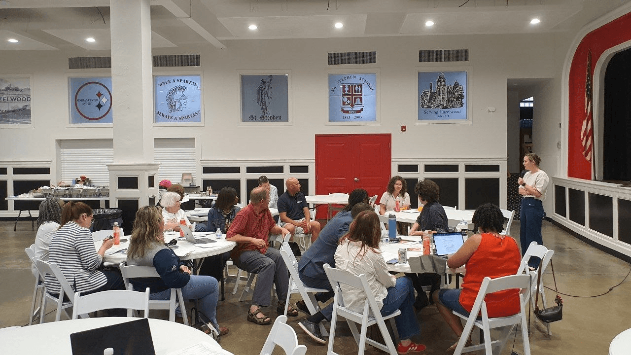 GHCC membership meeting, community members gathered around tables.